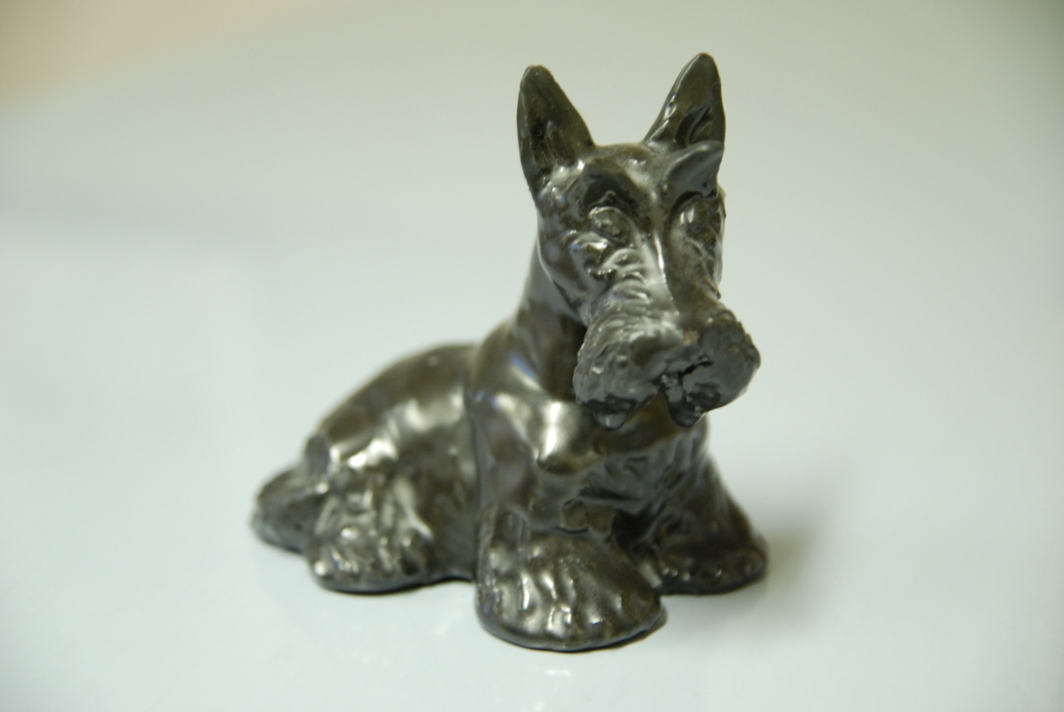 Figurin, hunden Skotte, lergods, svart glasyr, formgiven av Märta Willborg, 1930-talet.