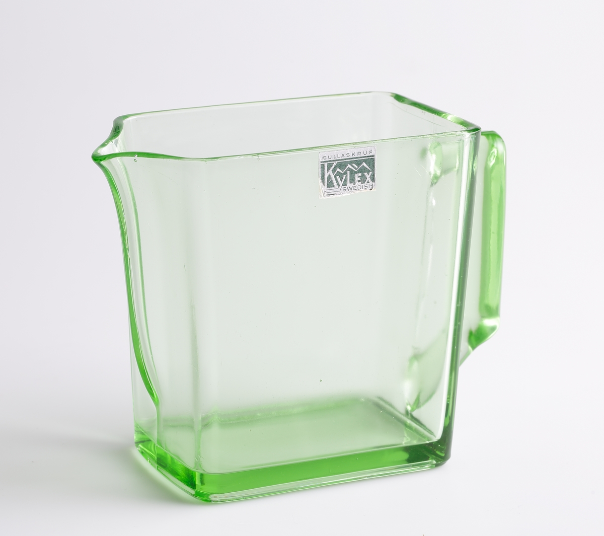 Rektangulär, stor kanna/kylskåpsglas. Närmast en kub med handtag på ena kortsidan och snip på den andra. Rektangulär etikett i grönt och silver med text "Gullaskruf Kylex Swedish".

Inskrivet i huvudkatalogen 1980.