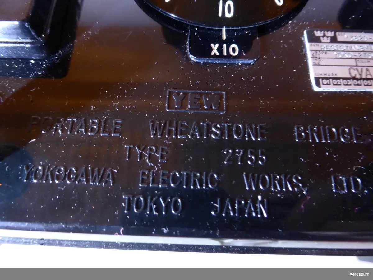 En orange televäska med en svart resistansbrygga i bakelit och en mätspänningskälla i grå metall. Tillverkade av Yokogawa Electric Works, Ltd. från Japan.