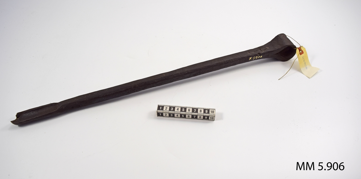 Nedre änden utsmidd till skär. Den övre vriden till ögla för handtag för vridning av borret. 

Märkt med ett uppochner vänt V med ett streck igenom.