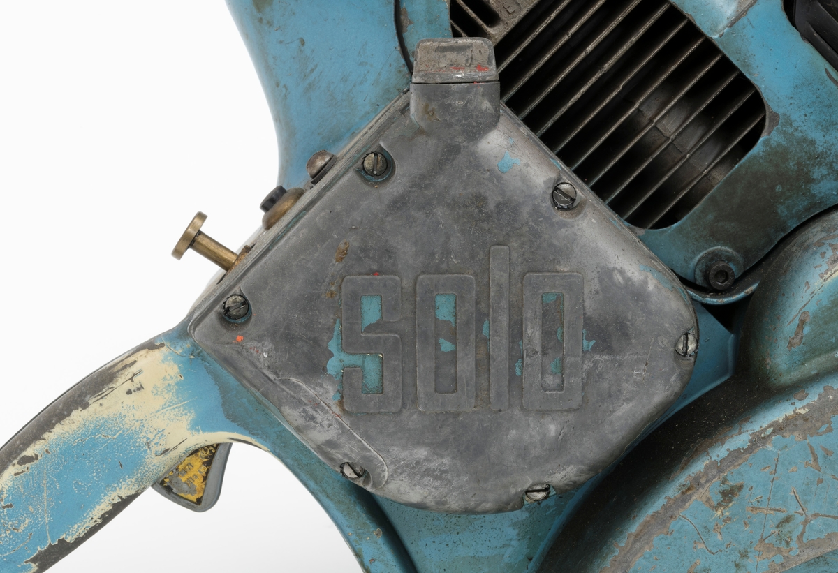 Motorsag av typen Solo Rex påmontert sverd, sagkjede og barkstøtte. For registrator ser det ut til at denne sagas bensintank er montert  under motoren med påfylling av bensin i framkant av motorkroppen og tilkobling til forgasseren i bakkant. Dekselene som omslutter sagkroppen er påført blå lakk som er delvis vekkslitt på enkelte partier.
Saga er utstyrt med mebranforgasser og den har direktedrevet kjede. Membranforgasseren gjorde det enklere å endre sagas posisjon, for eksempel fra kappe- til fellestilling, uten at motoren ble kvalt, stoppet. Direktedrevet kjede vil si motorkraften oveføres direkte fra veivakselen til sagkjedet, drivhjulet for for sagkjedet sitter på veivakselen forbundet med en clutch/kløtsj, sentrifugalclutch. (Se boka Motorsaga, Oslo 1963). 

Ut fra medfølgende lapp til saga og andre kilder gjengis det her noen tekniske spesifikasjoner: 
Sylindervolum (slagvolum): 125 kubikkcentimeter
Effekt: 5,2 hestekrefeter [også oppgitt til 6 hk ved 5200 omdreininger per minutt]
Vekt: 13,2 kg  [også oppgitt til 12,9 kg]

Saga trenger oljeblandet bensin i blandingsforholdet 1:25.