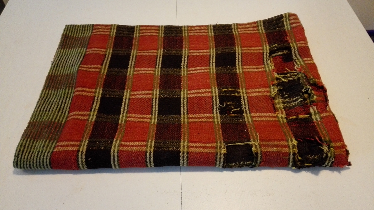 1 sadelteppe

Vævet sadelteppe, sammensydd av to tepper, altså dobbelt. Længde 150 cm, bredde 104 cm. Noe slidt og hullet. Vævet i ruter av rødt, gulhvitt, grønt og sort ullgarn. I enderne striper av grønnt og hvitt ullgarn.