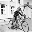 Sergeant Ponke sitter på en cykel utanför fotohandeln på Brahegatan 35b i Gränna.