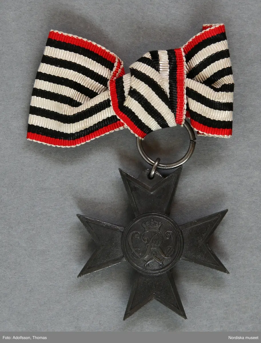 Huvudliggaren:
"Belöningstecken, stjärna av grå metall med mittrundel, på vars sidor står krönt 'R W' resp. 'Für Kriegshilfsdienst; i svart-vit-röd bandrosett med säkerhetsnål.
G 30/8 1955 Fröken Ellen von Platens dödsbo, Stockholm."