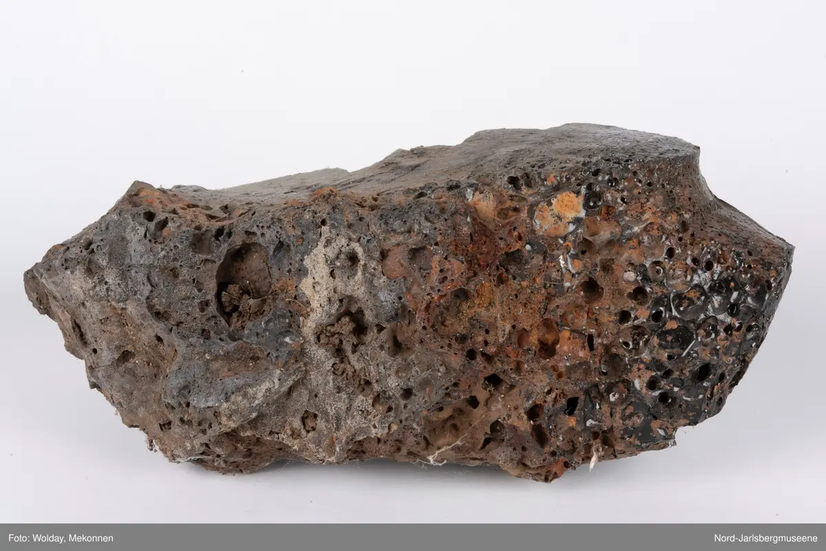 En større slaggstein fra formkasse, flere biter av slagg. Slagg er restproduktet etter at jernmalmen ble smeltet i masovnen, og jernet fjernet. Slagg er stivnete restmineraler som ofte blir en porøs, glassaktig stein.