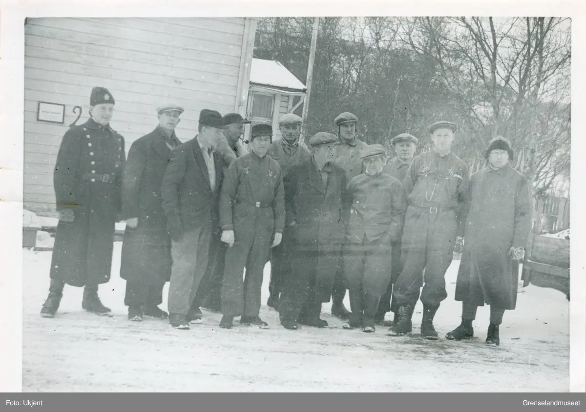 Som del av lærerstriden i 1942 ble flere lærere fra Sør-Varanger satt i arrest i april/mai 1942. Bildet viser en arbeidsgjeng på Prestegården. De er under politibevoktning. Fra venstre; Politibetjent, Julius Tro, Andreas Løvberg, Paul Kjelsberg, Tormod Larsen, Henry Lund, Axel Borgen, Sverre Dølvik, Harald Dahl, Hans Stangnes, Asmund Rørsleth, Jens Rotnes.
