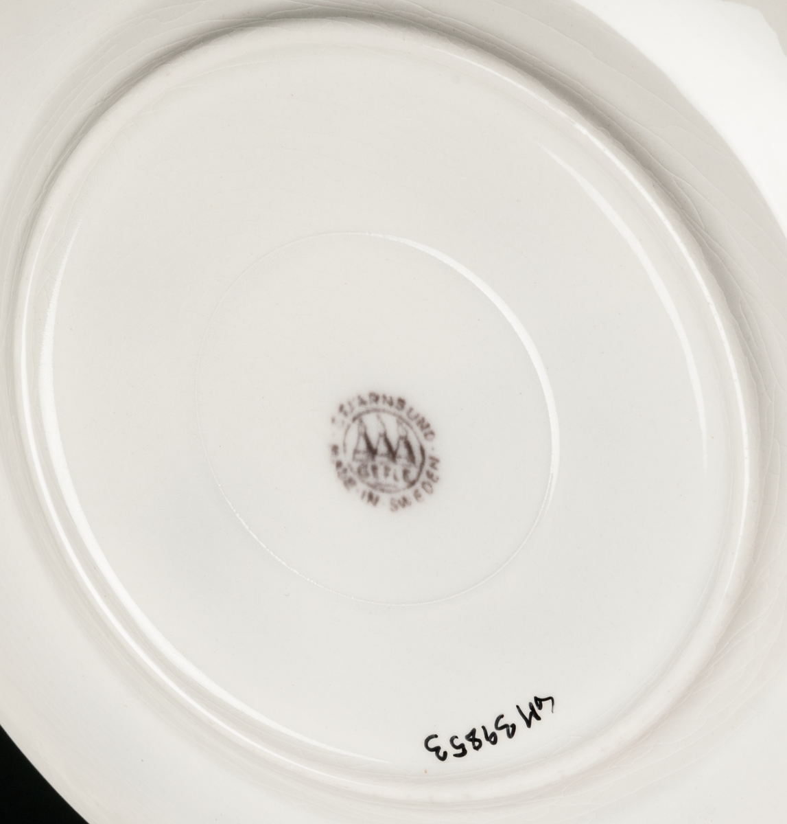 Assiett dekor Stjärnsund. Koppargravyrtryck i mullbärsbrunt.
Vit massa med brun dekor av blomster.
Bård i godset längs brämet.