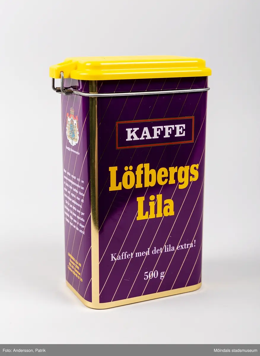 Rektangulär plåtburk med patentlock i plast, för förvaring av kaffe. Burken har ett tvärrandigt tryck i lila och guld, samt texten: 
Kaffe (tryckt i vitt inuti en röd ram)
Löfbergs Lila (tryckt i gult) 
”Kaffet med det lila extra!” (tryckt i vitt) 
500g (tryckt i vitt)
På ena kortsidan finns även ett riksvapen med texten Kunglig Hovleverantör tryckt. Locket är i gul plast.