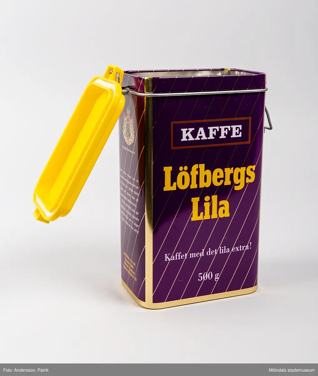 Rektangulär plåtburk med patentlock i plast, för förvaring av kaffe. Burken har ett tvärrandigt tryck i lila och guld, samt texten: 
Kaffe (tryckt i vitt inuti en röd ram)
Löfbergs Lila (tryckt i gult) 
”Kaffet med det lila extra!” (tryckt i vitt) 
500g (tryckt i vitt)
På ena kortsidan finns även ett riksvapen med texten Kunglig Hovleverantör tryckt. Locket är i gul plast.