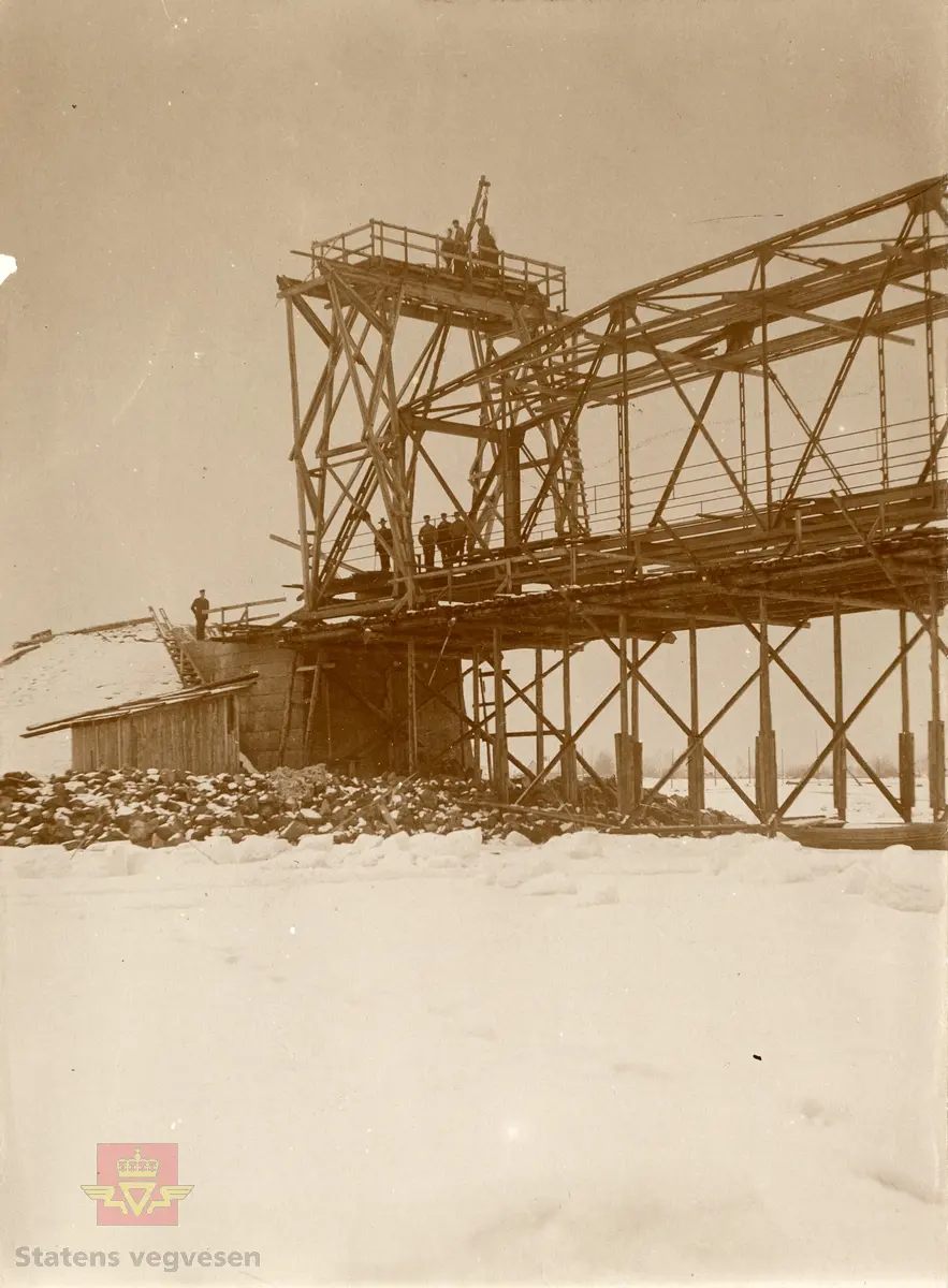 Monteringsarbeid nær høyre (vestre) bredde. Fot: 14.03.1911. AB? Fotoarkiv 307.
Håndskriften på bildet ligner tidligere vegdirektør Andreas Baalsrud. 
Bilde 2) Gamle Flisa bru under bygging. NVM 00-F-36623-1
Bilde 3) Konvolutt til gamle Flisa bru merket med brunr og fylkesveg/riksveg. NVM 00-F-36622-1