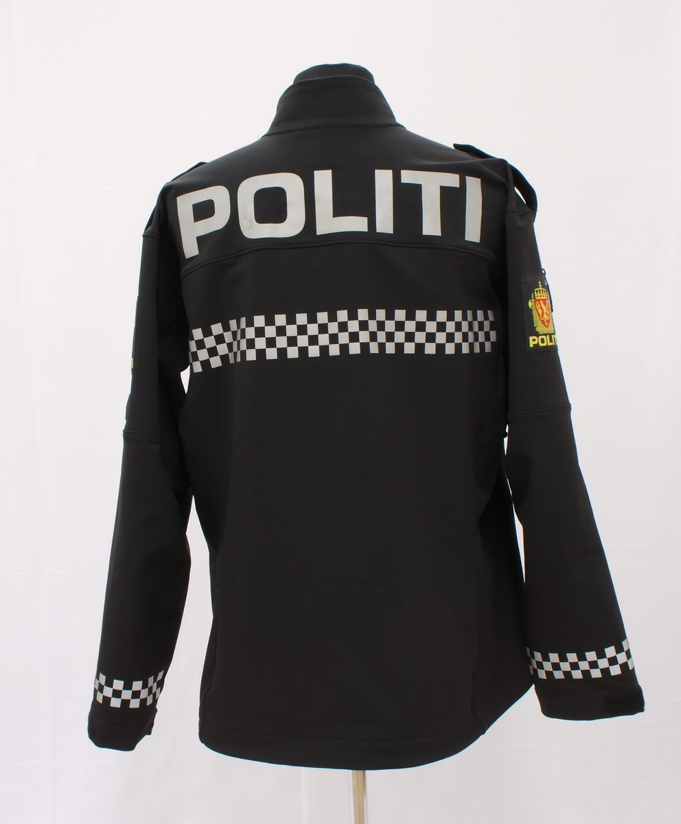 Sort politijakke i tre lag. 

En uniformert softshelljakke utstyrt med bæreløsninger for sambandsutstyr etc. og reflekser. 

En uniformert skalljakke i goretex, som kan bæres alene eller utenpå softshelljakka. Denne er også utstyrt med bæreløsninger og reflekser. Den er vann- og vindtett, og har hette. Begge jakkene har politimerke på begge overarmer. 

(Det tilhørende innerste laget mangler. Dette er en isolasjonsjakke uten politimerking. Jakka skal bæres som et varmende lag under de andre jakkene.)