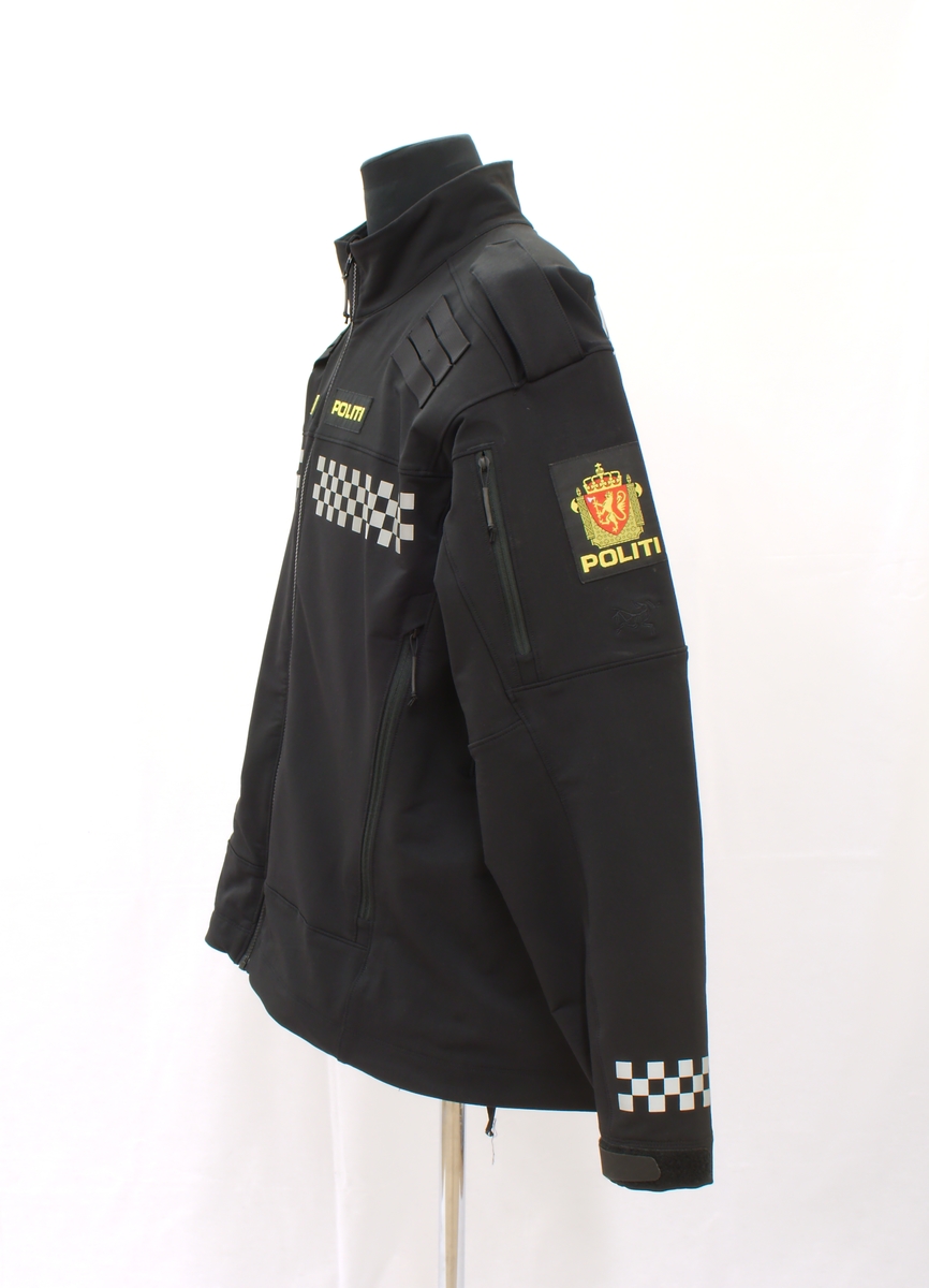 Sort politijakke i tre lag. 

En uniformert softshelljakke utstyrt med bæreløsninger for sambandsutstyr etc. og reflekser. 

En uniformert skalljakke i goretex, som kan bæres alene eller utenpå softshelljakka. Denne er også utstyrt med bæreløsninger og reflekser. Den er vann- og vindtett, og har hette. Begge jakkene har politimerke på begge overarmer. 

(Det tilhørende innerste laget mangler. Dette er en isolasjonsjakke uten politimerking. Jakka skal bæres som et varmende lag under de andre jakkene.)