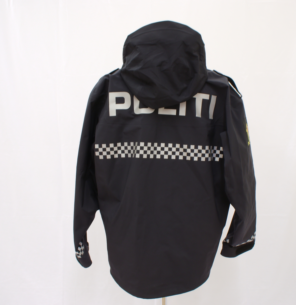 Sort politijakke i tre lag. 

En uniformert softshelljakke utstyrt med bæreløsninger for sambandsutstyr etc. og reflekser. 

En uniformert skalljakke i goretex, som kan bæres alene eller utenpå softshelljakka. Denne er også utstyrt med bæreløsninger og reflekser. Den er vann- og vindtett, og har hette. Begge jakkene har politimerke på begge overarmer. 

(Det tilhørende innerste laget mangler. Dette er en isolasjonsjakke uten politimerking. Jakka skal bæres som et varmende lag under de andre jakkene.)