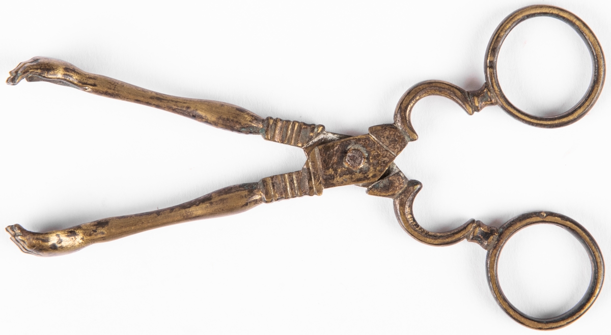 Sockertång, mässing. Sockertångsarmarna avslutas med ett par händer.