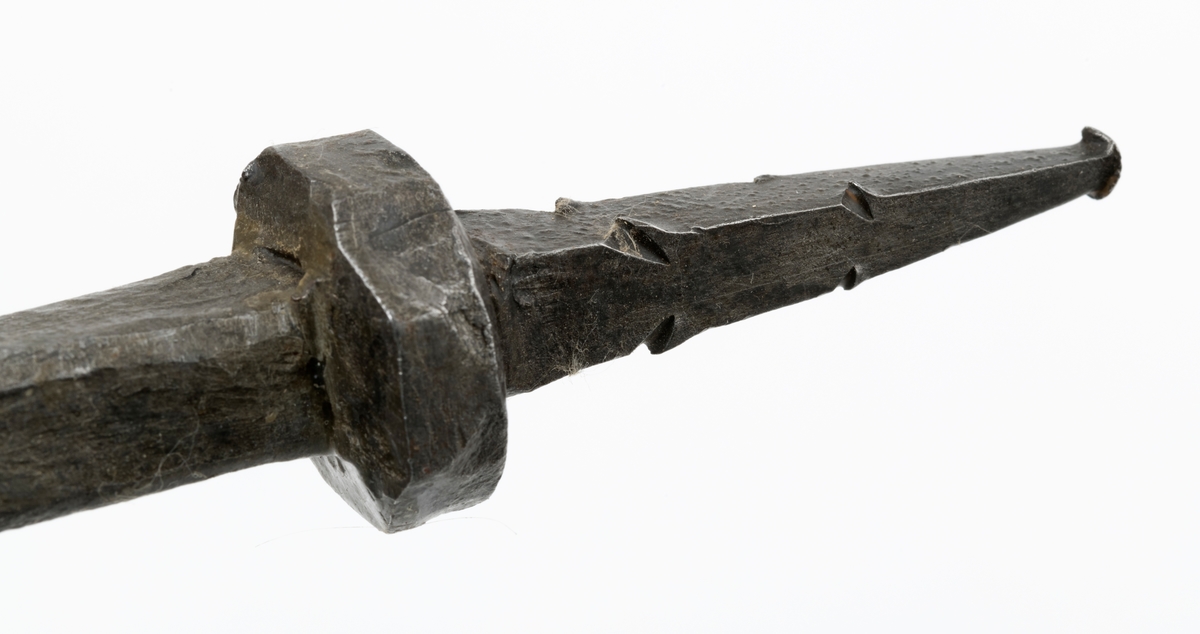 Stemjern med kraftig klinge, muligens så kraftig at den kan karakteriseres som en lokkbeitel, altså et redskap som kunne brukes til å bryte løs flis fra tapphull og andre djupe spalter i et arbeidsstykke av tre. Redskapet er 24,2 centimeter langt. Snaut 17,5 centimeter av dette lengdemålet er en klinge med en noenlunde rett, fasslipt egg i ytterenden. Denne eggen er cirka 2,2 centimeter bred.  Umiddelbart ovenfor eggpartiet har klingen et rektangulært tverrsnitt - 2,2 X 1,1 centimeter. Videre oppover smalner den i bredderetningen, men blir samtidig noe grovere og får et mer kvadratisk tverrsnitt (1,5 X 1,3 centimeter). I overenden av klingen er det en inngående avsats med en tange i forlengelsen av klingens lengdeakse. Den nedre delen av tangen har et tverrsnitt på 1,4 X 1,2 centimeter. Derfra mot den ytre enden smalner den en jevnt. Tangen skulle føres inn i en åpning sentralt i den nedre enden av det treskaftet dette stemjernet antakelig har hatt. Den har hakk i ytterkantene som skulle hindre at den løsnet. Da redskapet ble avlevert til Norsk Skogbruksmuseum manglet skaftet, og i mangle av skaft ser det ut til at snekkeren har banket på enden av tangen med en hammer. Ytterenden av tangen er i hvert fall stuket. Denne redskapsdelen er 5,7 centimeter lang.

Dette stemjernet var antakelig rustent da det ble overlatt til Norsk Skogbruksmuseum. Museets personale har sørget for elektrolysebehandling og påfølgende impregnering med korrosjonsherdende voks.