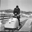 Paul Nes sitter och Rolf Möller står bakom på en snöskoter i ett mycket snörikt landskap.