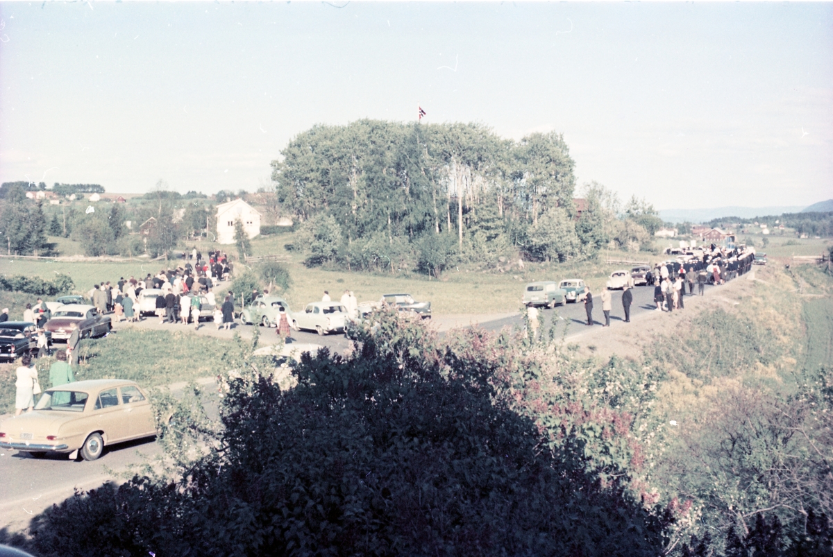 Serie på 16 bilder trolig fra Sangens og Musikkens Dag i Østre Toten, muligens 1961. Bildene er tatt i retning Brunsberg fra fotografens eiendom Odberg på Kraby, der forskjellige korps og kor deffilerer forbi.