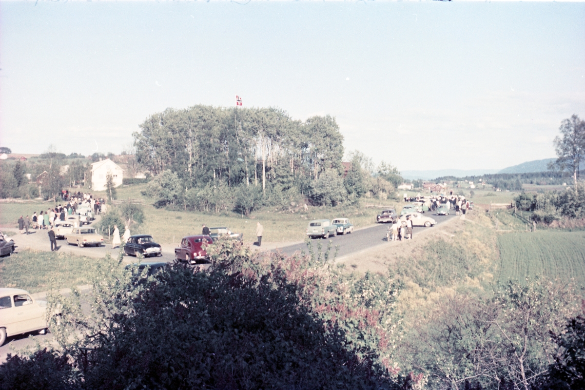 Serie på 16 bilder trolig fra Sangens og Musikkens Dag i Østre Toten, muligens 1961. Bildene er tatt i retning Brunsberg fra fotografens eiendom Odberg på Kraby, der forskjellige korps og kor deffilerer forbi.