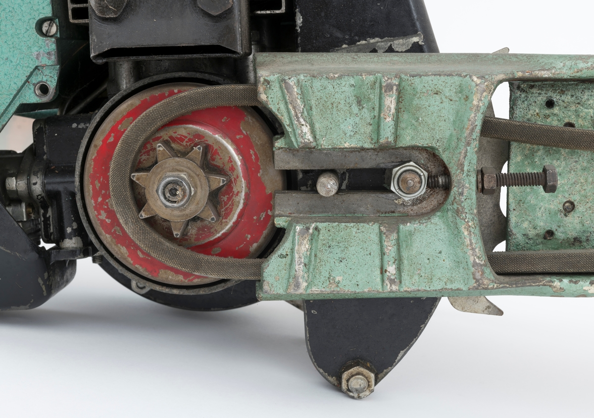 Motorsag av typen Jo-Bu D94 Tiger med påmontert barkeapparat (se beskrivelse nedenfor). Saga er også utsyrt med barkstøtte. Den fremre håndtaksbøylen er polstret med svart gummi rundt lettmetallrøret, cirka 11 centimenter langt felt, for å gi brukeren et bedre håndgrep. På toppen av sagkroppen, rett bak fremre håndtaksbøyle, gjenfinnes en kortslutningsbryter i blankt metall. For registrator ser saga komplett ut, kun tennpluggdeksel, tennplugghette og en skrue i startapparatet / starthuset mangler.  

Jo-Bu Tiger var den første direktedrevene saga fra Jo-Bu-fabrikken. Det vi si at kjedet settes i gang når motorens turtall overstiger et gitt antall omdreininger per minutt (2600). Når turtallet er under 2600 omdreininger står kjedet stille. (På tidligere Jo-Bu-modeller koblet man kjedet til og fra med en egen hendel.) Tiger var også den første Jo-Bu- modellen  med membranforgasser.  Dermed kunne den enkelt brukes til felling, kapping og kvisting uten at motoren stanset. (Flottørforgasseren, som var vanlig på de tidligere modellene, måtte stå i loddrett stilling for å fungere.) 

Særegent for denne saga (SJF.13864), er at sverd og kjede er byttet ut med et barkeapprat. Barkeapparatet som er montert på saga er av typen BRA-KAR (for mer informasjon om samme type barkeapparat se SJF.13709, store deler av beskrivelsesteksten er kopiert fra omtalen av denne gjenstanden.) Apparatet er en spesialkonstruert barkemaskin, barkeapparat, som kan kobles til motorsag eller drives med egen motor. Når appratet brukes på en motorsag byttes motorsagas sverd og kjede ut med barkeren (barkeapparatet), motorsagmotoren driver på den måte barkeren. Aggregatet /apparatet er festet til boltene i sverdfestet og skrudd fast med 2 muttre, en mutter mangler. 

Selve apparatet består av ei grønnlakkert ramme som i front er utstyrt med tre trinser, barketrinser. Trinsene er montert på akslinger som drives rundt av motorsagmotoren. Det er nødvendig med en egen tilkoplingsdel på motorsaga for å få barkeapparatet i drift. Registrator antar at kraften fra motosagmotoren overføres til barketrinsene via en tannhjulsveksel, snekkeveksel, som trinsene er direkte koblet til.  I bakkant av denne vekselen gjenfinnes en smørenippel for innpumping av fett. Apparatet har påmontert et stålhåndtak som er polstret med oransje gummi slik at brukeren får et mer behagelig grep.