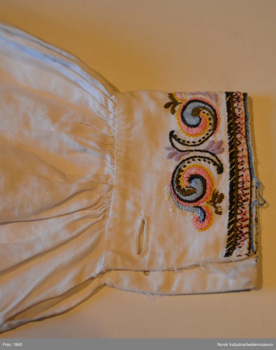 Bunadsskjorte i prinsessemønster til Øst-Telemarksbunad. Skjorta har farget broderi på kvarden, framstykket og ermlinningene.