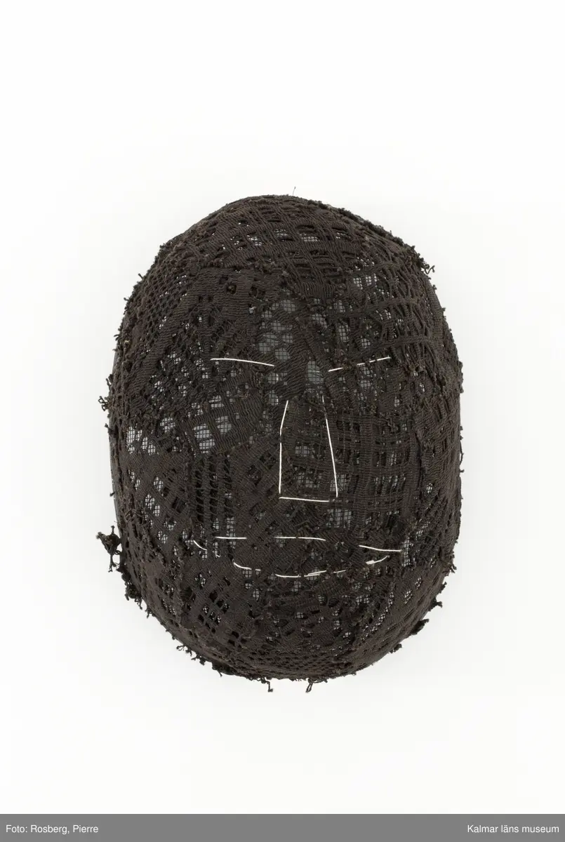 Svart oval fäktarmask med broderade ansiktsdrag i vitt.