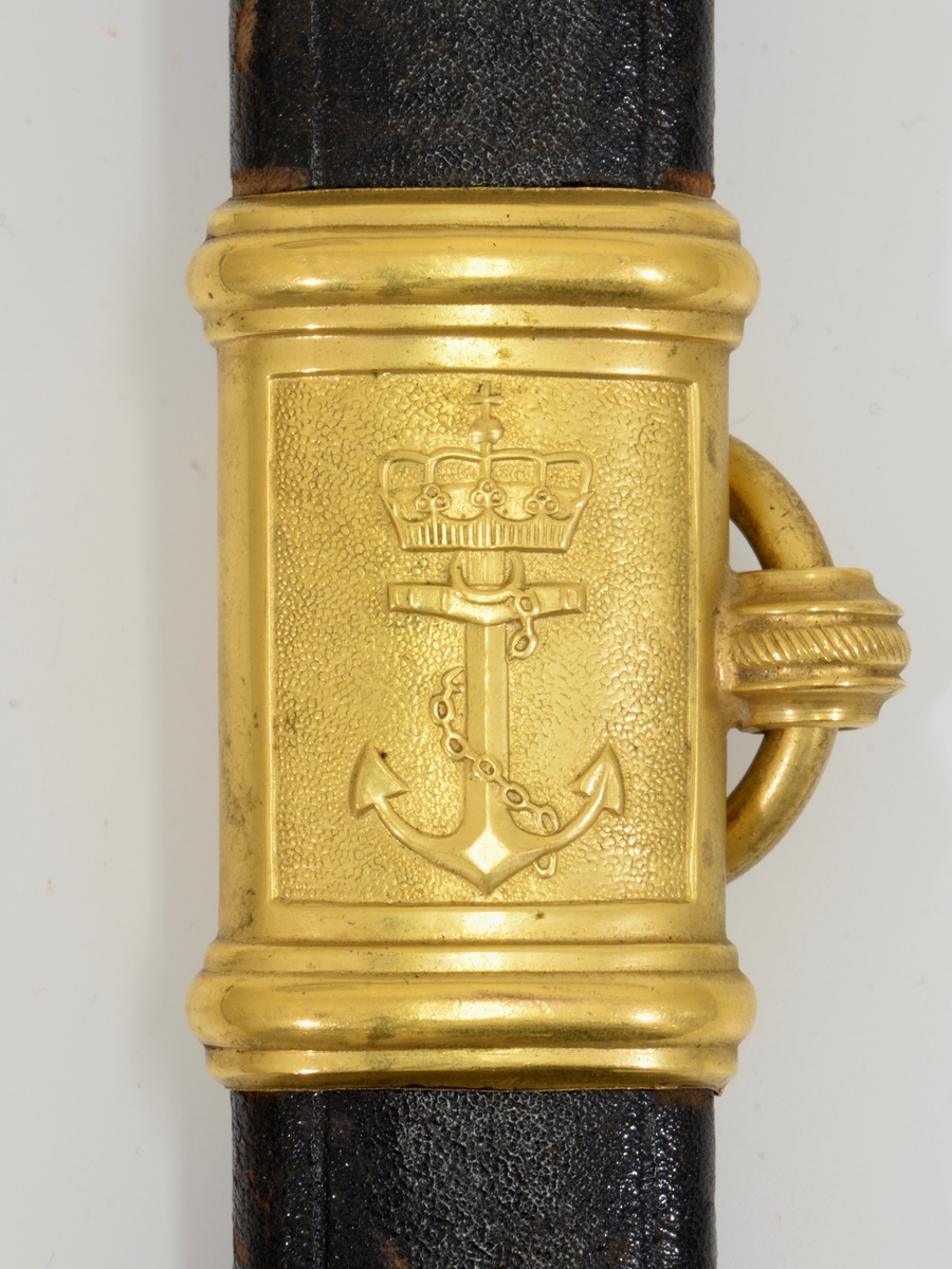 Norsk marinesabel Modell 1842. Feste i forgyllyt messing. Flat knapp med blomstermotiv. Nakkestykke merket "Lars Yggeseth"
Hvitt plastgrep med riller med snodd messingtråd i rillene. Gjennombrutt parerplate på utsiden med urent anker..Bakre parerstang svakt medbøyd og ender i en flattykt kule. Fremre parerstang går over i håndbøylen.
Gulltråde portepé flettet med alternativt svart/mørkeblått og gull.
Svakt krummet enegget klinge med rygg- og midtstillt blodrand. Klingen har etset dekor med moderne marinefartøy og kronet urent anker. Klimgen er merket med Carl Eichorns Solingenstempep i en oval rundt et ekorn.
Lærbalg med forgyllte messingbeslag. Munnblikket merket med norsk løve på forsiden og " Y " på baksiden. Midtbåndet er merket med kronet urent anker. Doppskoen har Neptuns tref ork og militære attributter.