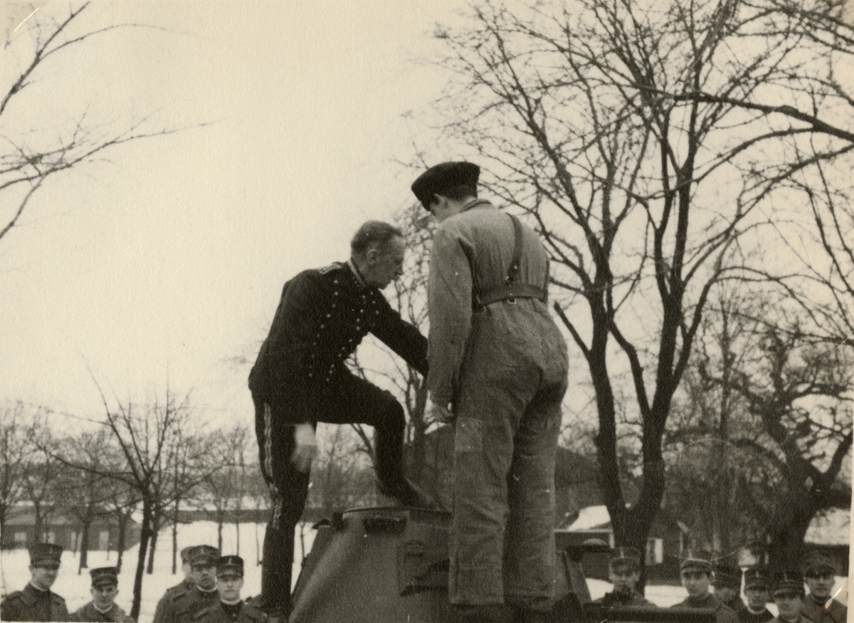 Text i fotoalbum: "AIHS studiebesök vid I 2 strdvbat (Göta livgardes stridvagnsbataljon) 19.1.1938. Överste Sjöberg är intresserad."