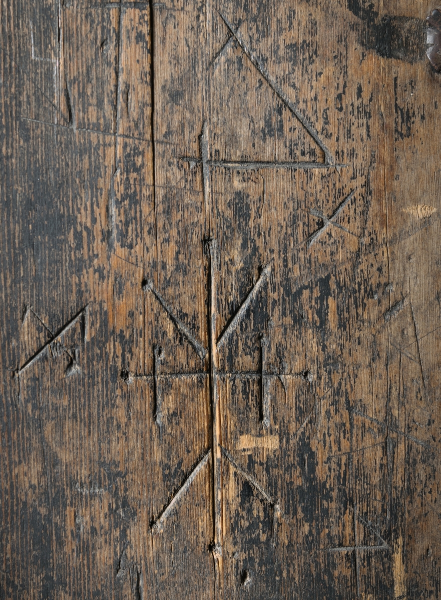 Kyrkdörr, romansk, kyrkport, med järnornament och beslag. Dörren består av tre lodräta, tjocka furuplankor, rundad upptill. Tre kraftiga gångjärn. I övrigt rikligt järnbeslagen. I ändarna av beslagen på en del ställen gapande djurhuvuden. Spår av tjära. Flera ristningar, bland annat armborst, konsekrationskors (invigningskors).