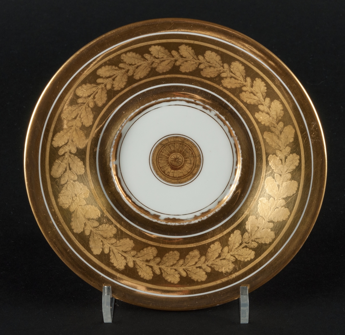 Karl XIII:S kopp.
Kopp med fat från Daite Freies i Paris, omkring 1800.
Koppens höjd 9.5 cm. Fatets diameter 16,5 cm.
Koppen bär på ena sidan Karl XIII:s bild och är på motstående sida dekorerad med ett par antika hjälmar.
Dekor i empirestil i guld och blått.
En grepe med örnhuvud och palmettdekor. Fatet är dekorerat med en eklövskrans.