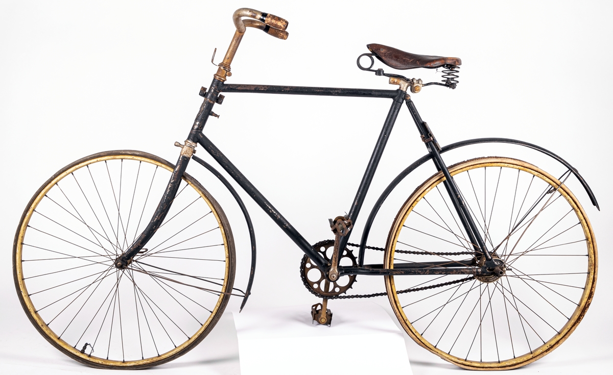 Cykel från 1800-talets slut.
Svartmålad. Gummidäck. Pakethållare i fram. Brun sadel av läder.
Den är tysk och är av märket Brennabor, modell No 1. Firman låg i Brandenburg.
Den är från sista årtiondena på 1800-talet.
Registreringsskyl i glas, nummer 5198.