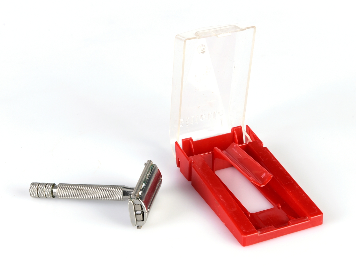 En barberhøvel i eske produsert av Gillette. Høvelen er laget av metall. Håndtaket er støpt slik at det er ruglete for godt grep. For å åpne/lukke høvelen skrur man nederst på håndtaket. Skrur man mot høyre åpnes den og man kan sette inn barberblad. For å lukke den skrur man mot venstre. Esken er laget av plast. Den nederste delen er rød og har et stativ som høvelen skal ligge i. Under er det et rom for å legge barberblader i. Lokket er av blank plast og er hengslet fast. På både høvel og eske er det stempel, se "Påført tekst/merker".