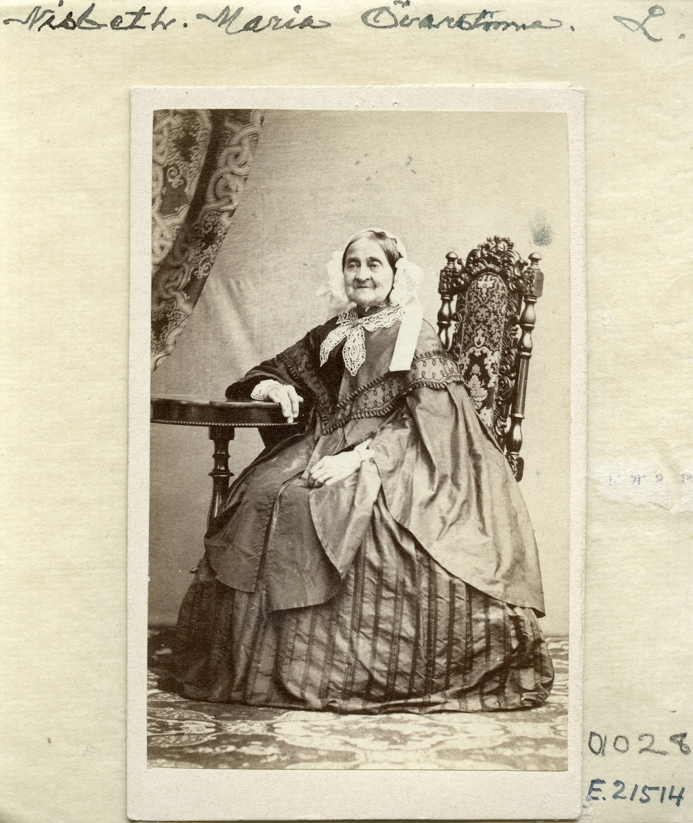 Porträtt av änkefru Maria Nisbeth. Född som Maria Jacobina Barfoth i Lund 1784 gifte hon sig 1810 med dåvarande kaptenen Johan Georg Nisbeth. I sinom tid utnämndes maken till överste vid Andra livgrenadjärregementet i Linköping och från 1827 bodde makarna på Smedstad strax söder om Linköping. I hushållet fanns även fosterdottern Maria Elisabeth Wallenberg. Efter makens bortgång 1834 följde en lång änkeperiod på Smedstad för Maria. På ålderns höst flyttade hon till sin stadsgård i Linköping och där somnade hon in den 17 januari 1868.