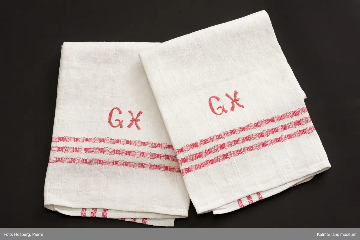 KLM 44279:1 Handukar med monogram, 2 stycken. Vita med tre röda ränder som bildar bård runt om. Hängare isydd upptill. Monogram: G H, (Gerda Holmgren).