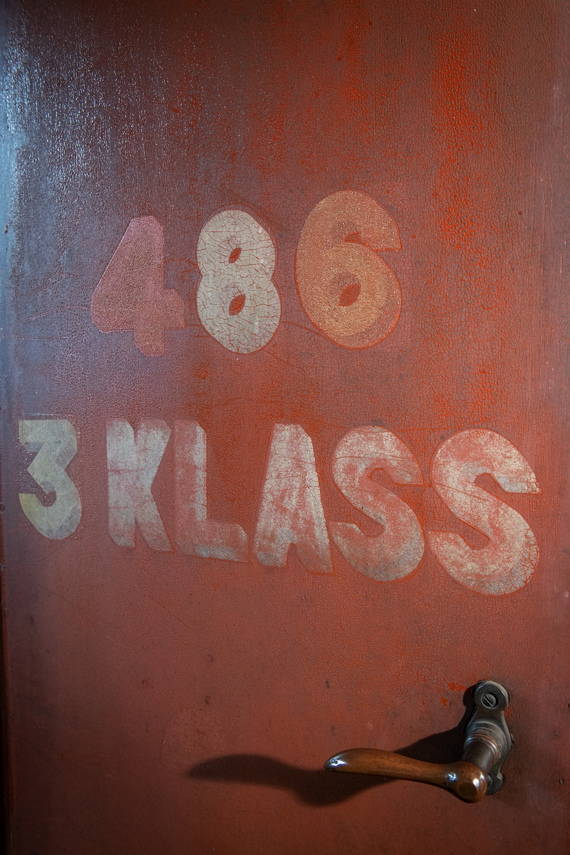 Personvagn SJ BC 486, f.d. SJ C6 486.
I gott avställningsskick som omodern äldre vagn något återställd till utförande som kombinerad före 1923. Rödbrunt ytskikt från ommålning efter att färgsystemet vid SJ gjordes om 1924. Plattformar i båda vagnsändar.

Andraklassdelen upptar 3/5 av vagnen och består av två kupéer för sammanlagt 12 personer, korridor och klosettrum. Korridoren är klädd med panel och ådringsmålad invändigt i ljus ekimitation. Det är skjutdörrar till andraklasskupéerna och en dörr in till tredje klass. Väggarna i andraklasskupéerna är klädda med brunblommig vaxduk och i taket sitter en ljus prickig vaxduk, samt stearinljusbelysning och blå nattskärmar av tunt fint kläde. Sofforna är väggfasta, med svarvade ben och klädda med tigermönstrad mokett (yllesammet med kort lugg), stoppade med tagel och har möbelsnoddar längs med kanter och sömmar.
Ovanför sofforna sitter hatthyllor med vitmålade gjutjärnskonsoler och snörnät. Under sofforna sitter värmeelement eller någon form av tilluftsflöde och över fönstren finns ventiler. Det är olika fönsterremmar i olika kupéer och i korridoren, vävda, av läder och av textil. Samtliga golv i andra klass och tredje klass är av brun linoleum. Golvet är skarvat på flera ställen. I korridoren sitter en svart tavla för anslag. Klosettrummet har en toalett med trälock och en pissoar. Utanför klosettrummet sitter ett karaffställ av trä på väggen för en karaff och två glas.

Tredjeklassdelen består av en dubbelkupé för 18 personer, utan mellanvägg men med öppning för passerande. Tredjeklassdelen har till skillnad från andra klass endast ett fönster mellan varje soffpar. Sofforna är utförda som spjälsoffor på järnstomme. Även resgodshyllorna är av träspjälor ådringsmålad i ljus ek liksom tak och väggar. Gjutjärnskonsolerna till hatthyllorna är rödmålade. Golvet är detsamma som i övriga vagnen.  

Vita mönstervävda gardiner med SJ:s emblem.