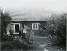 Lillhärad sn, Västerås.
Skräddartorp. Familj stående utanför bostaden. 1900-1910.