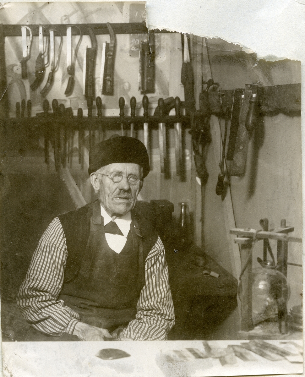 Kung Karl sn, Kungsör.
Edvard Hedberg, en Sveriges sista kammakare, sitter vid sin arbetsbänk med kammar framför sig och sina verktyg på väggen bakom sig.