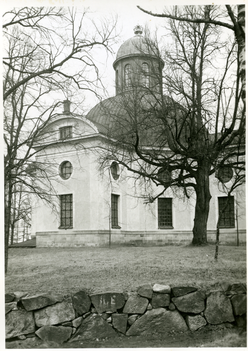 Kung Karl sn, Kungsör.
Exteriör av Kung Karls kyrka, med stenmur i förgrunden.