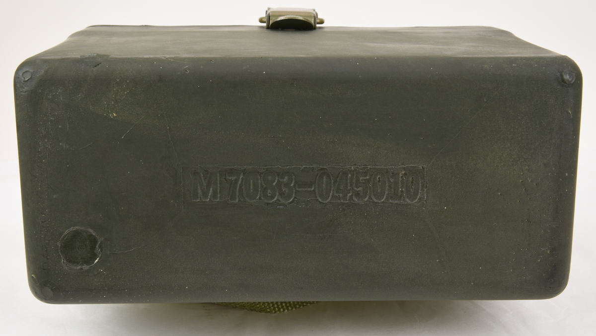 Krypteringsapparat (:1) med hölje av grönmålat aluminium i rundade former. Översidans framkant är lätt fasad och har ett avlångt fönster med alfabetet i över- och nederkant. Fönstret är till för att visa den alfabetsrulle som gav lösningen på kryptot. Under fönstret finns en svart skylt med vit text där siffrors bokstavskoder visas. På ovansidans mitt finns fem smala chifferhjul av svart bakelit i en försänkning. Hjulen är till för att ställa in chiffrets bokstäver som syns i ett fönster längst upp på apparatens ovansida. Till höger om chifferfönstret finns ett räkneverk med fyra siffror.

På apparatens framkant finns en skylt med M-nummer, serienummer och liknande och till höger ett vred av svart bakelit för att mata fram alfabetsrullen. På apparatens vänstra sida finns ett frammatningsvred av metall samt tillverkarens logotyp. På den högra sidan finns en lucka för alfabetsrullen och ett vred av bakelit för att ställa in chifferhjulaxeln. Baksidan har en större lucka för hålkortsplatsen och undersidan har små gummifötter samt en dekal med information om garantitid.

Till apparaten hör också en transportväska (:2) av formgjuten och genomfärgad gummi. Väskan är grön och har en vävd bärrem fäst med mässingsskruv. Locket är fäst med ett avlångt, nitat gångjärn och har ett låsspänne i mässing. På locket finns tre kronor och apparatens M-nummer i relief och på väskans undersida finns väskans M-nummer. Insidan av väskan är formad efter kryptoapparaten för att ge så mycket skydd som möjligt.

M-nummer: M 3858-301010
Tillverkningsnummer: 22749

Väskans M-nummer: M 7038-045010