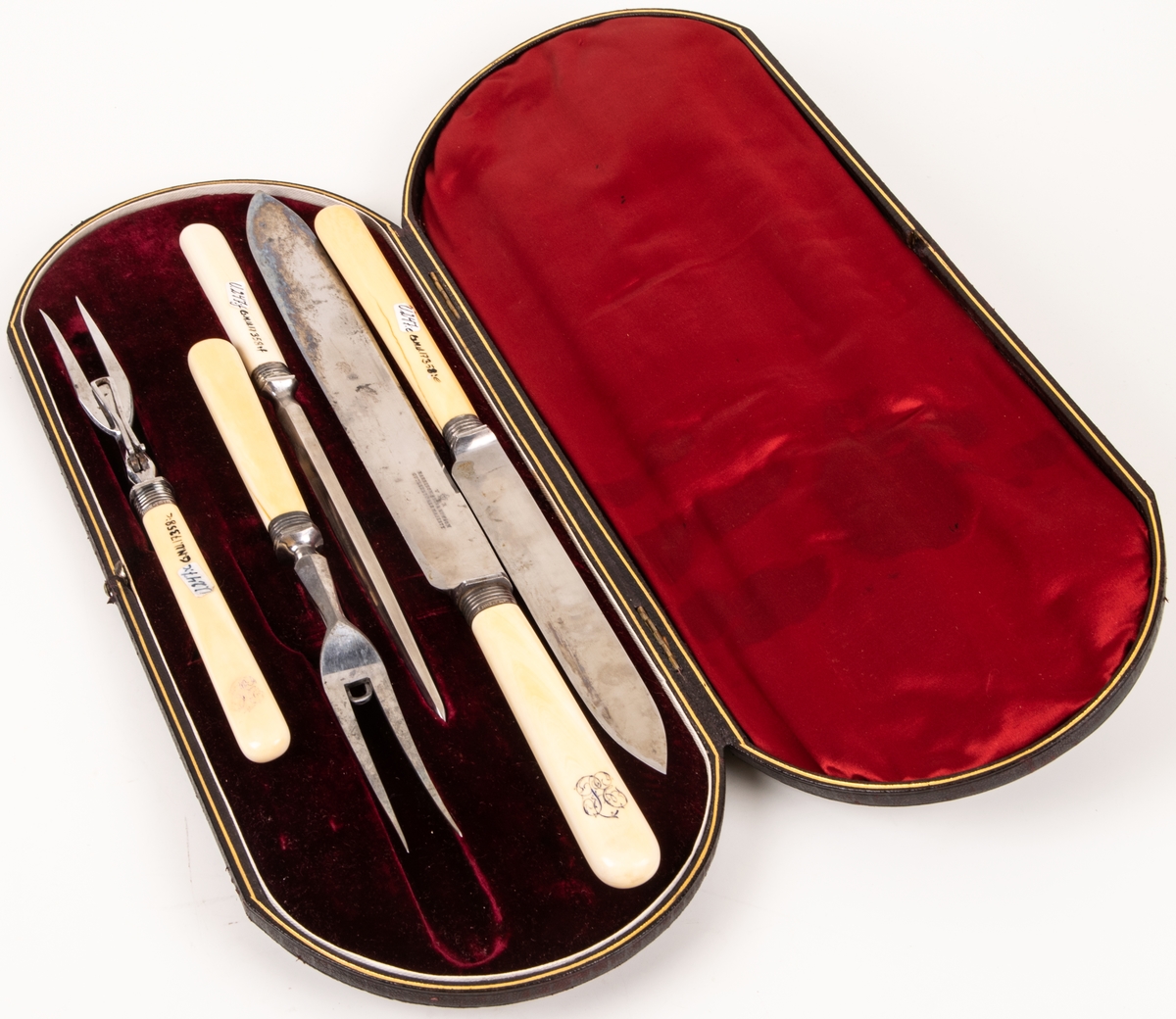 Stekgarnityr i svart fodral med initialerna P.E. i guld. Skaft med snirkligt monogram. Stämpel "V R".

Harrison Bros & Hovsson Cutlers to her Majesty.