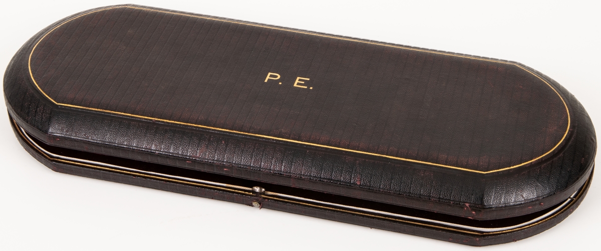 Stekgarnityr i svart fodral med initialerna P.E. i guld. Skaft med snirkligt monogram. Stämpel "V R".

Harrison Bros & Hovsson Cutlers to her Majesty.