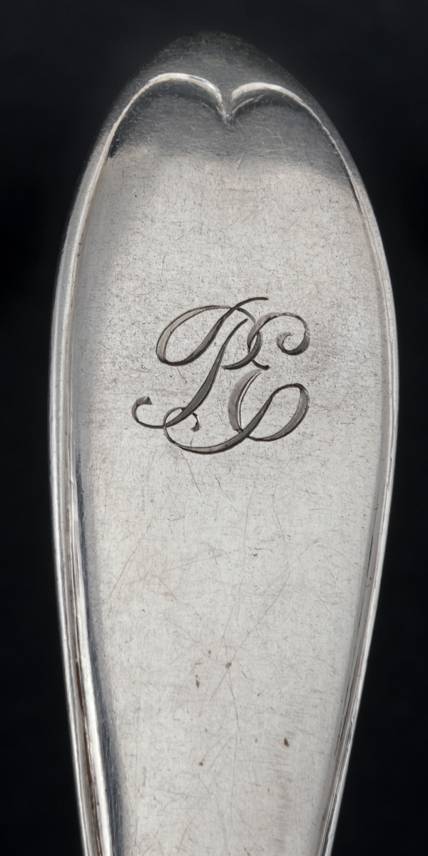 24 stycken dessergallar av silver. Linjeartat ornament på skaftet. Gammelfransk modell.
Stämplad: GM D7 Kontrollstämpel, Sthlm.
Monogram: PE