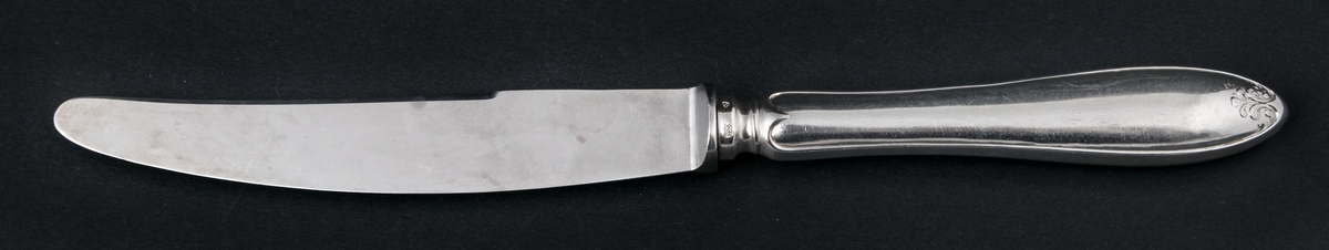 24 stycken matknivar av silver. Linjeartat ornament på skaftet. Gammelfransk modell.
Stämplad: GM F7 Kontrollstämpel, Sthlm.

Monogram: PE