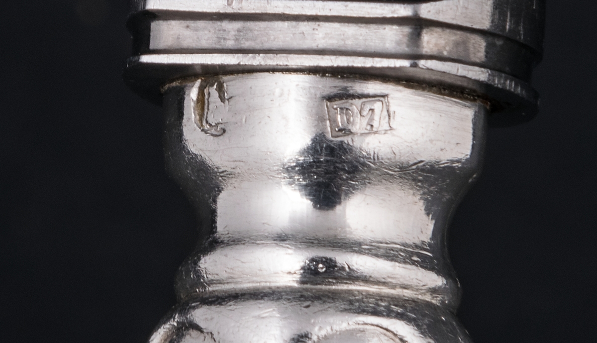 36 stycken matknivar av silver. Linjeartat ornament på skaftet. Gammelfransk modell.
Stämplad: GM D7 Kontrollstämpel, Sthlm.
Knivbladet: E. Jernmanuf. Aktiebolag, Eskilstuna.
Monogram: PE