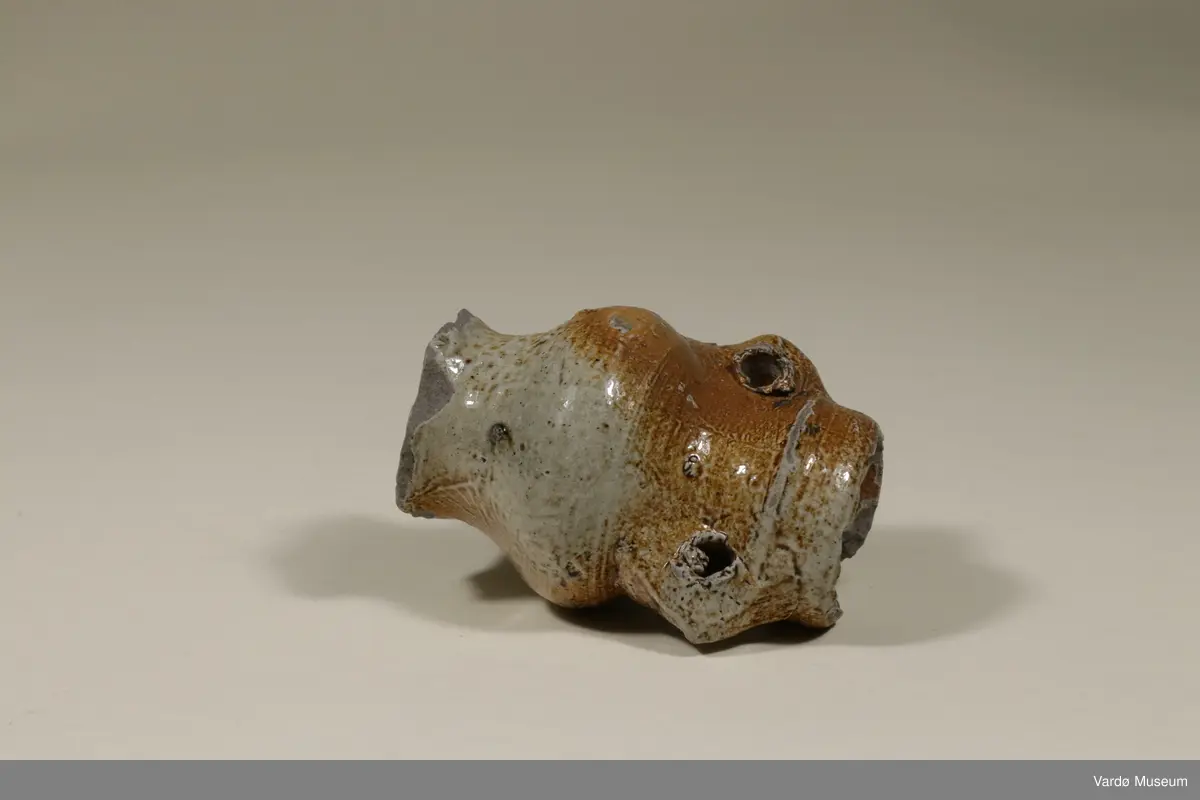 Spinnekrukke av tysk fabrikat. Tuten er knust. Krukken ble funnet i Brodtkorbgaten  i Vardø. krukken er fra 1400-tallet. 