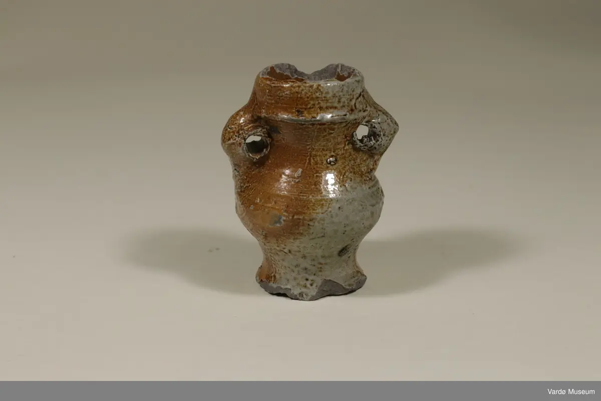 Spinnekrukke av tysk fabrikat. Tuten er knust. Krukken ble funnet i Brodtkorbgaten  i Vardø. krukken er fra 1400-tallet. 