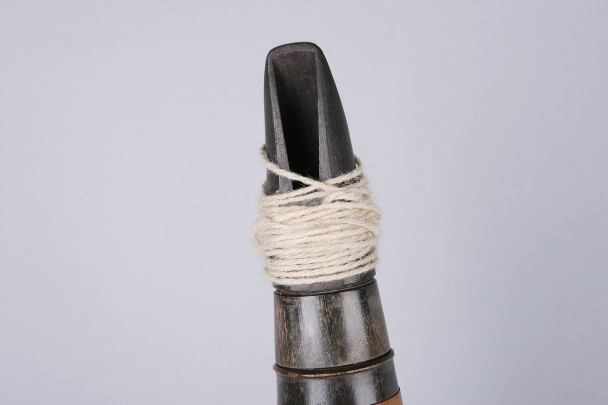 Lyst tre. Seks deler. Fem ringer av horn? To er profilert og tre flate. 5 klaffer av messing, fire lukkede og en åpen, 7+1 fingerhull. Munnstykket av ibenholt.
Klaffer for e, fiss, giss, a1 og b1.
