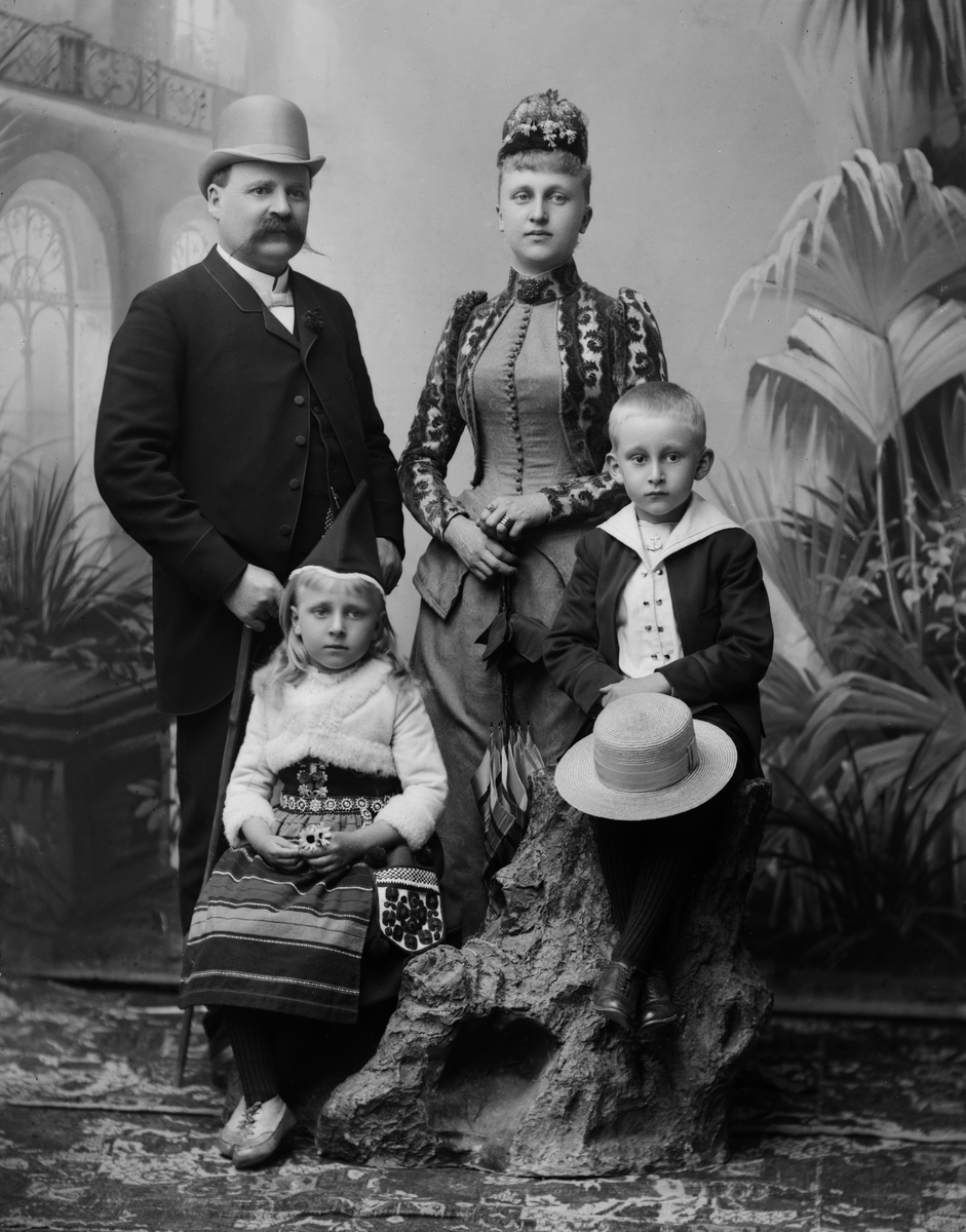 Porträttfotografi föreställande Axel Peterzén, handlande, fru Hilma född Gylling, dottern Anna gift Ljunggren, son okänt namn . 

Porträtt. Familj. Man. Kvinna. Ateljéfotografi.  

Fotograferad i Maria Teschs ateljé som fanns i Linköping åren 1873 - 1936. 

Digitaliserad efter original glasnegativ som förvaras på Stiftsbiblioteket /Linköpings stadsbibliotek.