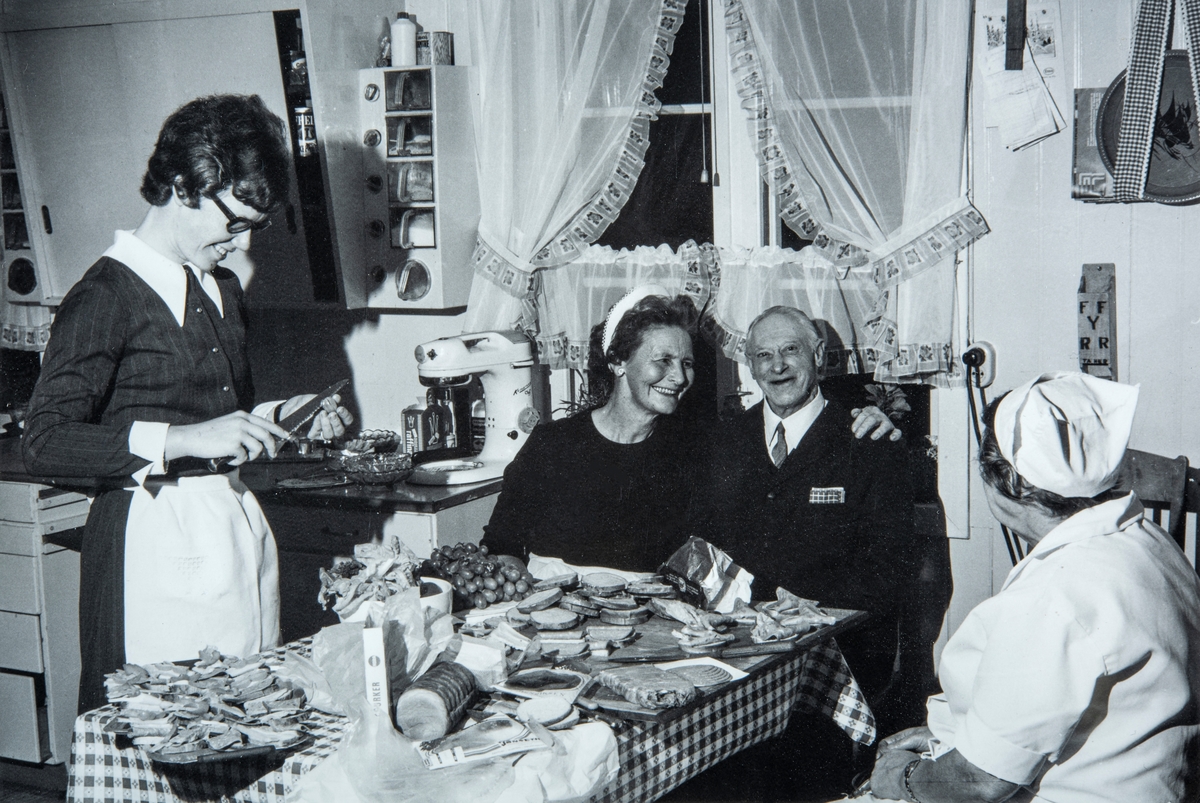 Fra kjøkkenet på Kjøs (81/1). Forberedelser til servering i Ole Kjøs’ konfirmasjon i desember 1970.  Fv. Bjørg Busterud fra Dæli, Martha Olsen fra Nydal, Kristoffer Ruud som bodde på Kjøs og Eline Bergsvenkerud.
