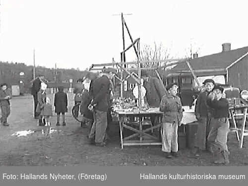 G25102 "Skällinge gamla marknadsplats ligger nu öde och tom."
G25104 "Ett par minnesgoda mannar, Edvard Nilsson, Attorp och Oscar Carlsson, Tågarp, vet mer om Skällinge marknad än någon annan." G25106 "En leksakshandlare - den ende på Skällinge marknad". 
Bilderna är publicerade i Hallands Nyheter 1947-12-17.