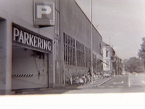 Domus parkeringshus i Halmstad. Fotot visar infarten till parkeringshuset och längs fasaden står en räcka cyklar parkerade.
Bild i samband med miljövårdsutställningarna med bl a, "Miljön i Halland", som visades på museet, 1970-07-03--07-26."